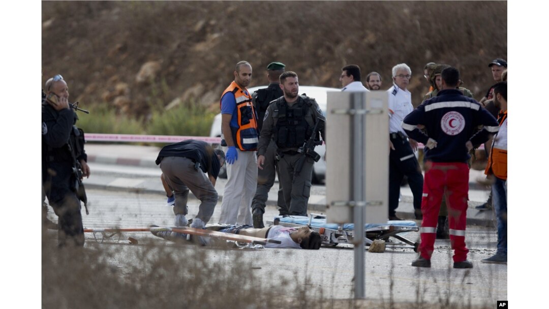 An Israeli forensic officer inspects the body of a Palestinian man at a checkpoint near the West Bank town of Nablus, Oct. 30, 2015.