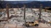 FILE - A vehicle rests in front of a home leveled by the Camp Fire in Paradise, Calif., Dec. 3, 2018. Authorities estimate it will cost at least $3 billion to clear debris of 19,000 homes destroyed by California wildfires last month.