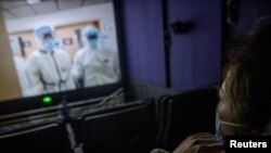 Una mujer observa el documental , “Días y noches en Wuhan” en un cine de Beijing el 22 de enero de 2020.