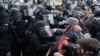 ​Oficiales de policía del Capitolio con equipo antidisturbios hacen retroceder a los manifestantes que intentan romper una puerta del Capitolio de los Estados Unidos el miércoles 6 de enero de 2021 en Washington.