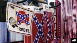 Banderas y letreros confederados son despelgados en Little Rock, Arkansas.