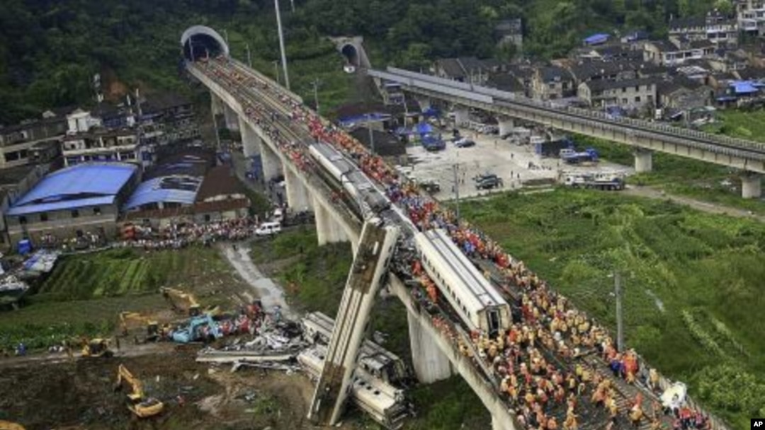 Ma'aikatan ceto, dauke da gawar wani da suka zakulo daga cikin buraguzon jirgin kasa daya goce ya fadi karkashin wata gaba a Wenzhou, lardin Zhejiang kasar China a ranar asabar.