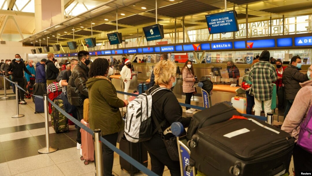 Passengers line up at John F. Kennedy International Airport after airlines announced numerous flights were canceled during the spread of the Omicron coronavirus variant on Christmas Eve in New York, Dec. 24, 2021.