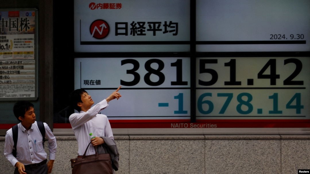 2024年9月30日，日本東京一家股票交易所外的電子螢幕顯示下跌的日經平均指數。