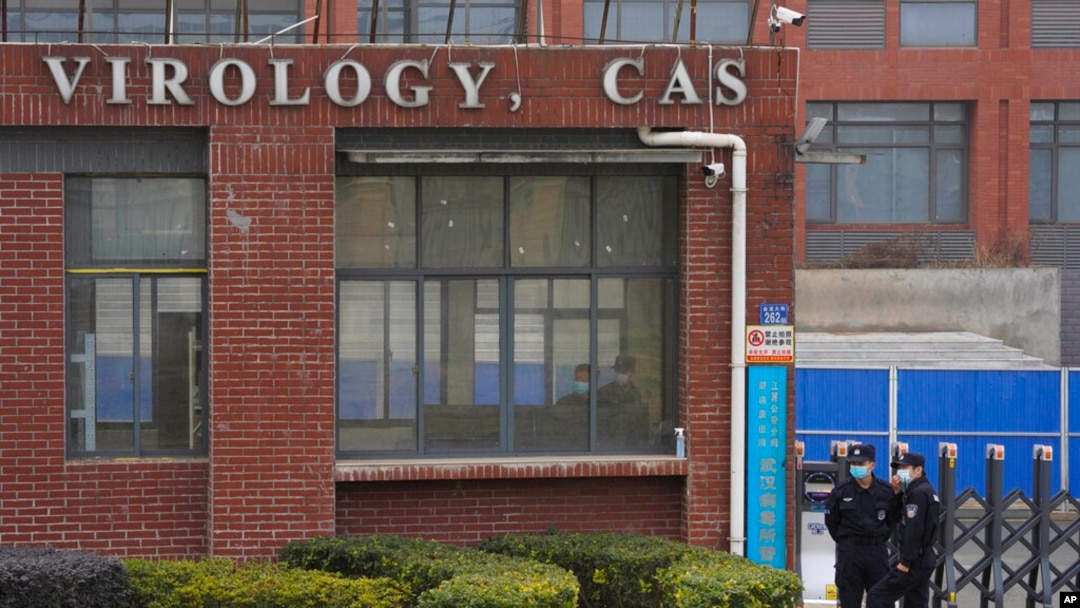 FILE - Security personnel gather near the entrance of the Wuhan Institute of Virology during a visit by the World Health Organization team in Wuhan, China, Feb. 3, 2021. 
