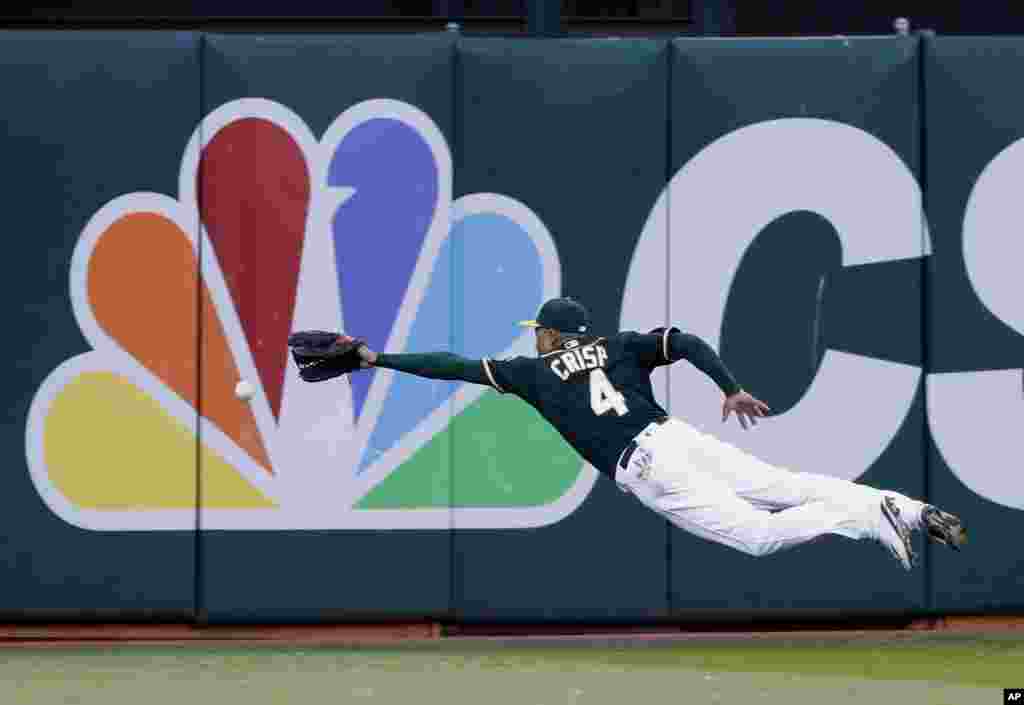 Oakland Athletics left fielder Coco Crisp dives for, but can't catch, a line drive from Houston Astros' Luis Valbuena during the second inning of a baseball game, in Oakland, California, July 18, 2016.