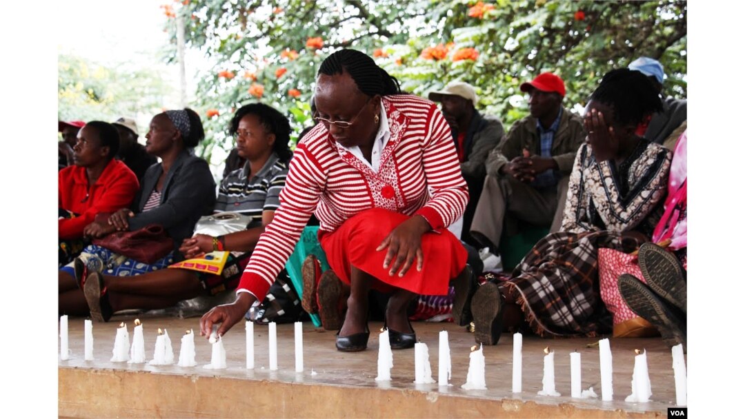 A relative lits a candle to remember her niece who died in the hands of al-Shabab gunmen in Garissa, northeastern Kenya. (Mohammed Yusuf/VOA)