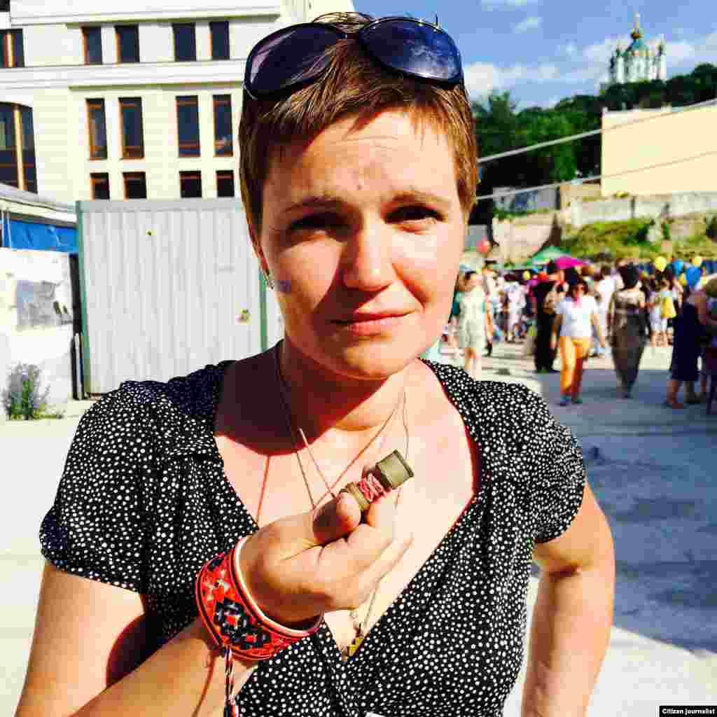 Lesya Litvinova shows a rubber bullet that she wears to remind herself why she is a volunteer, June 3, 2015. (Daniel Schearf/VOA)