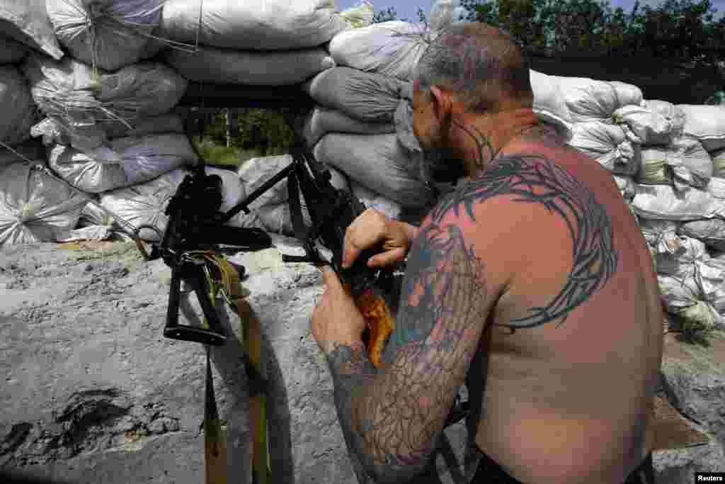 A pro-Russian militant defends a front line position with a machine gun, Slovyansk, Ukraine, May 19, 2014. 