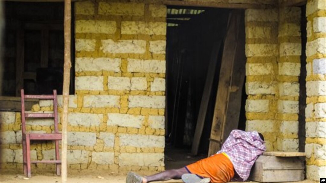 FILE - A man suffering from the Ebola virus lies on the floor outside a house in Port Loko Community, situated on the outskirts of Freetown, in Sierra Leone, Oct. 21, 2014. 