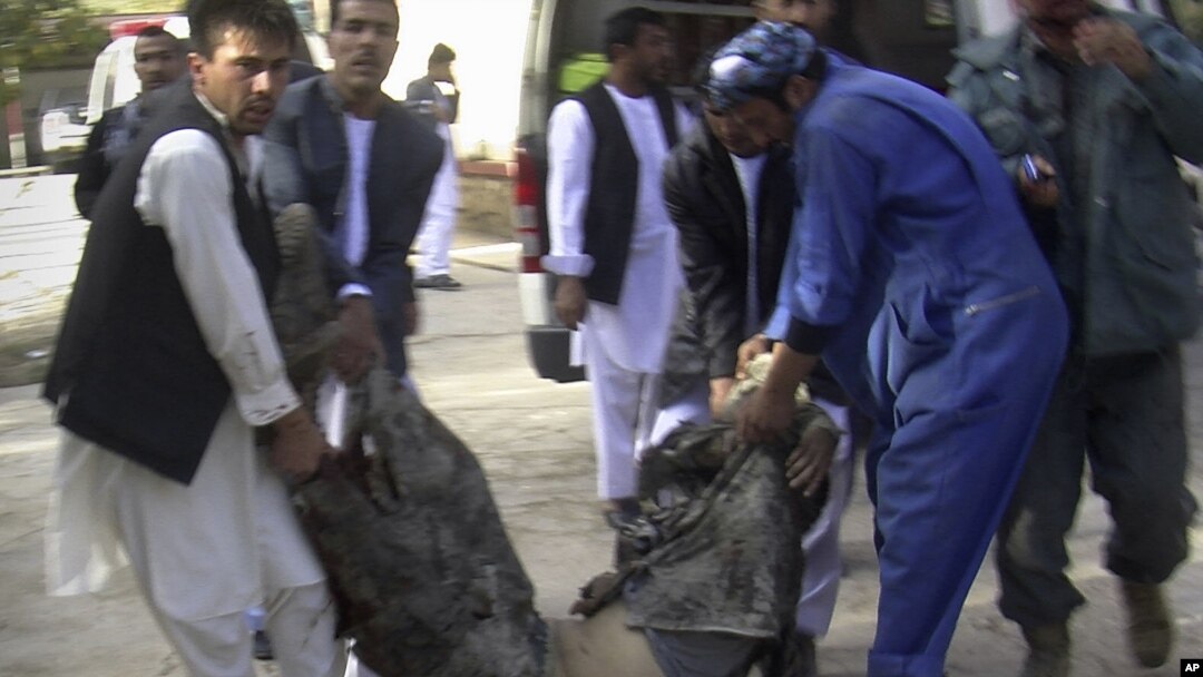 Afghans carry the body of a suicide attack victim at the hospital in Maymana, Faryab province northwest of Kabul, Afghanistan, October 26, 2012.