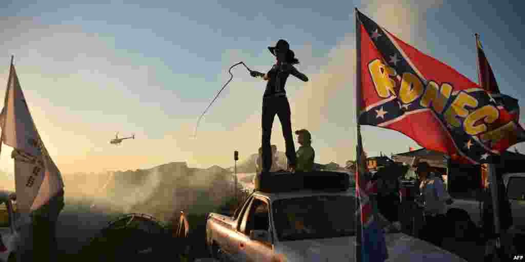 Photo taken on September 29, 2018 shows a reveller cracking a bull whip on top of her ute at the annual Deni Ute Muster in Deniliquin.