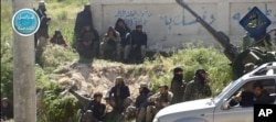 FILE - This image posted on the Twitter page of Nusra Front, April 25, 2015, shows Nusra Front fighters in the town of Jisr al-Shughour, Idlib province, Syria.