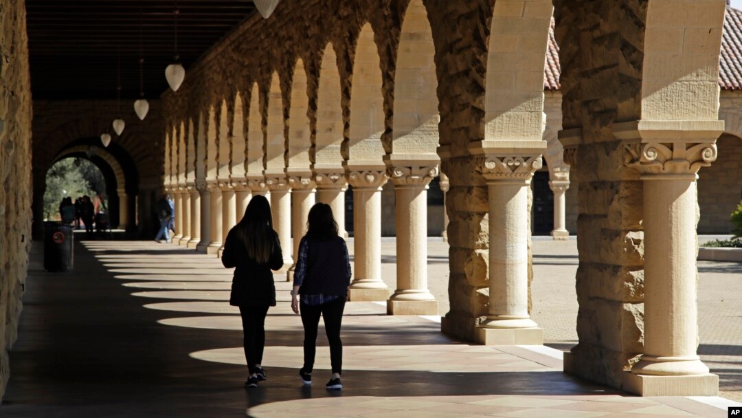 FILE- Students walk on the Stanford University campus in Santa Clara, Calif., March 14, 2019.