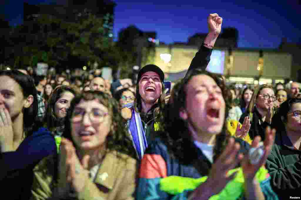 People react as they watch news coverage of the release of Romi Gonen, Doron Steinbrecher and Emily Damari, three female hostages who have been held in Gaza since the deadly October 7 2023 attack, in Tel Aviv, as part of a ceasefire deal in Gaza between Hamas and Israel.