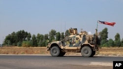 FILE - A U.S. military vehicle, part of a convoy, arrives near Dahuk, Iraqi, Oct. 21, 2019.