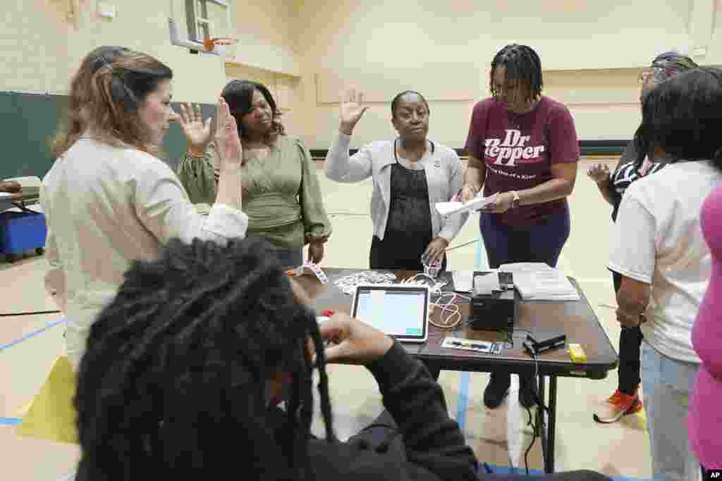 Funcionários eleitorais em North Jackson, Mississippi, recitam o seu juramento de posse antes de abrirem o local para os eleitores de manhã cedo, a 5 de novembro de 2024.