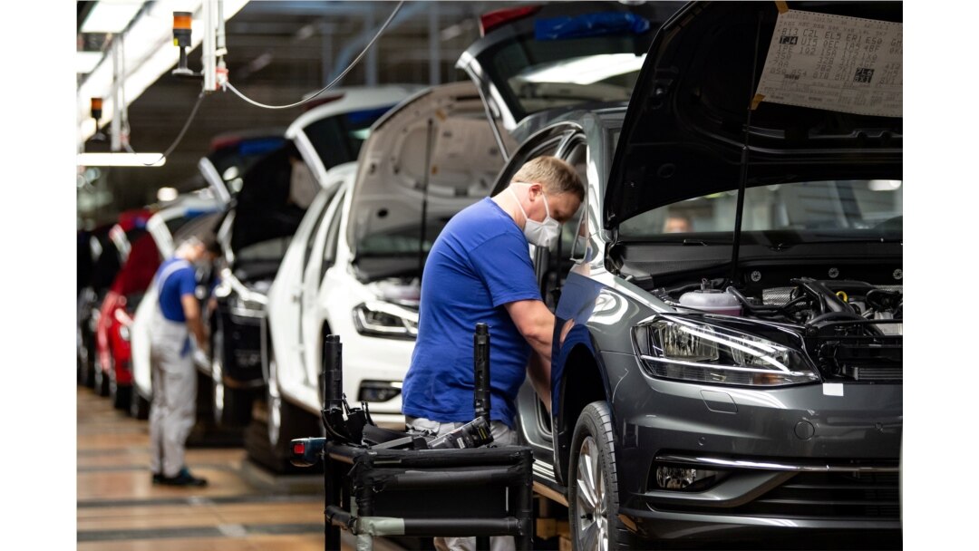 FILE - A worker wears a protective mask at the Volkswagen assembly line after VW re-started Europe's largest car factory after a coronavirus shutdown, in Wolfsburg, Germany, April 27, 2020.