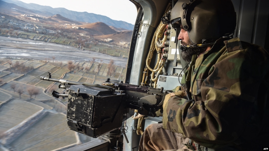 Taliban security personnel keep watch from a helicopter two days after airstrikes by Pakistan in the Barmal district of eastern Paktika province, Afghanistan, on Dec. 26, 2024.