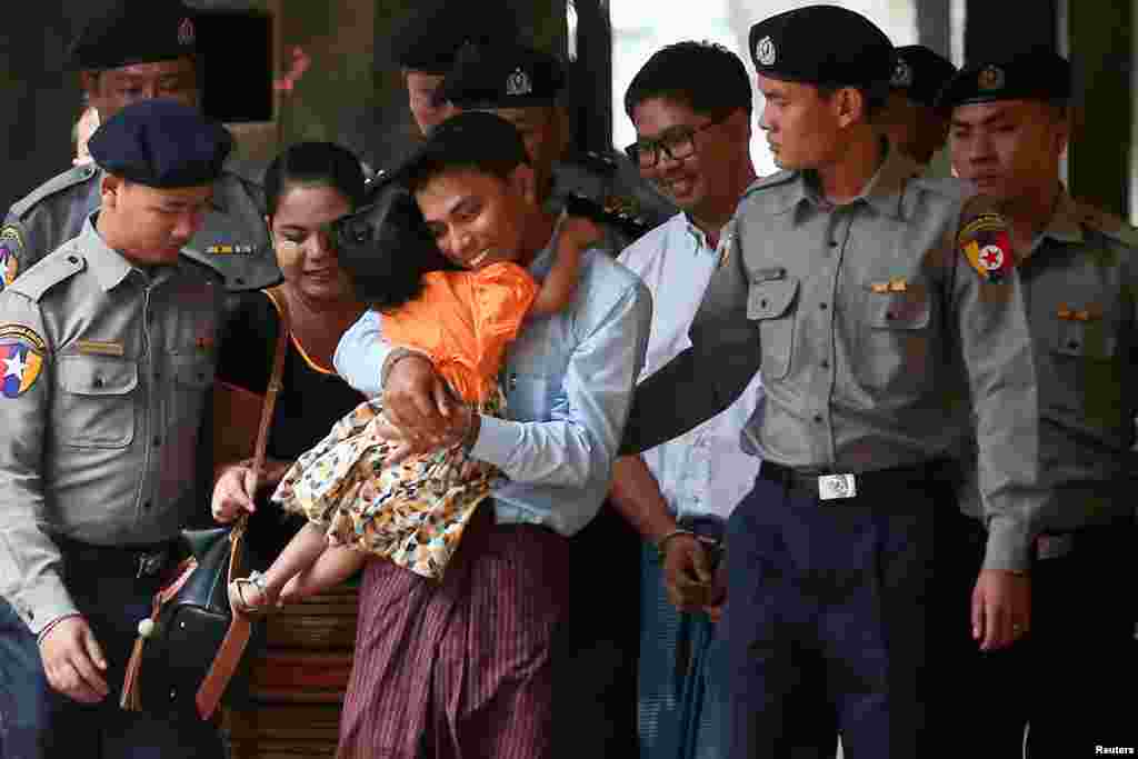 Detained Reuters journalist Kyaw Soe Oo hugs his daughter as he is escorted by police for a court hearing in Yangon, Myanmar.