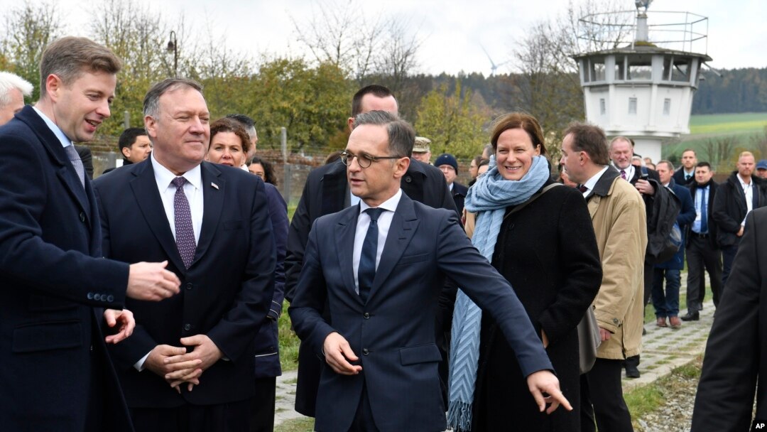 German Foreign Minister Heiko Maas, right, talks with U.S. Secretary of State Mike Pompeo, 2nd left, during their visit at the German village of Moedlareuth near Hof, eastern Germany, Nov. 7, 2019. 