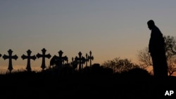 Isaac Hernandez and his wife Crystal visit a line of crosses before a vigil for the victims of the First Baptist Church shooting, Nov. 6, 2017, in Sutherland Springs, Texas.
