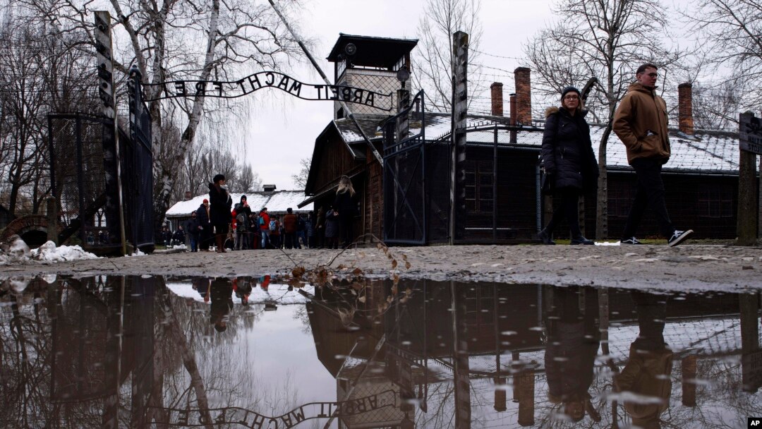 La gente camina junto a la puerta ''Arbeit Macht Frei" (El trabajo te libera) en el antiguo campo de concentración y exterminio alemán nazi Auschwitz-Birkenau en Oswiecim, Polonia, el jueves 26 de enero de 2023.