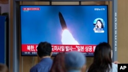 FILE - A TV screen showing a news program reporting about North Korea's missile launch with file footage, is seen at the Seoul Railway Station in Seoul, South Korea, Oct. 4, 2022.