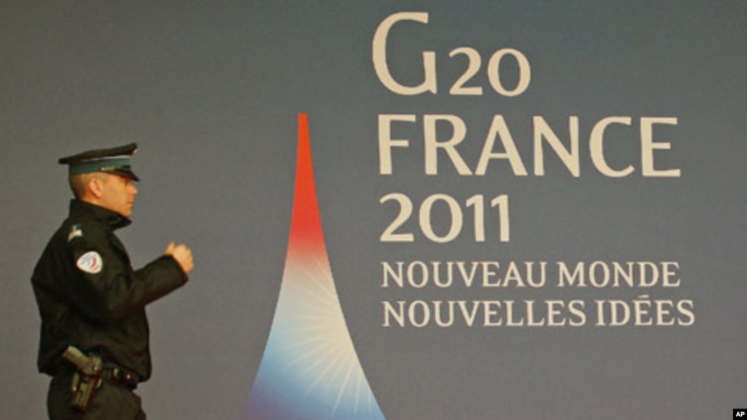 A French police officer walks past the G20 logo and slogan, 'New World, New Ideas,' outside the festival palace as preparations for the G20 summit continue in Cannes, France, November 2, 2011.