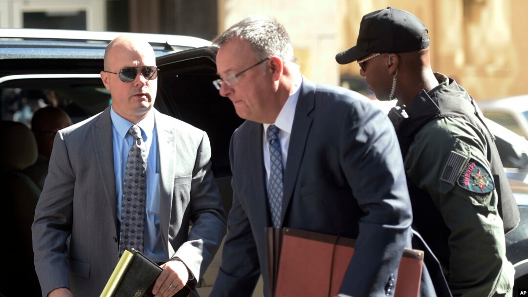 Lt. Brian Rice, left, one of the six members of the Baltimore Police Department charged in connection to the death of Freddie Gray, arrives with attorney Mike Davey, center, at a courthouse to hear a judge's ruling in his trial in Baltimore, July 18, 2016