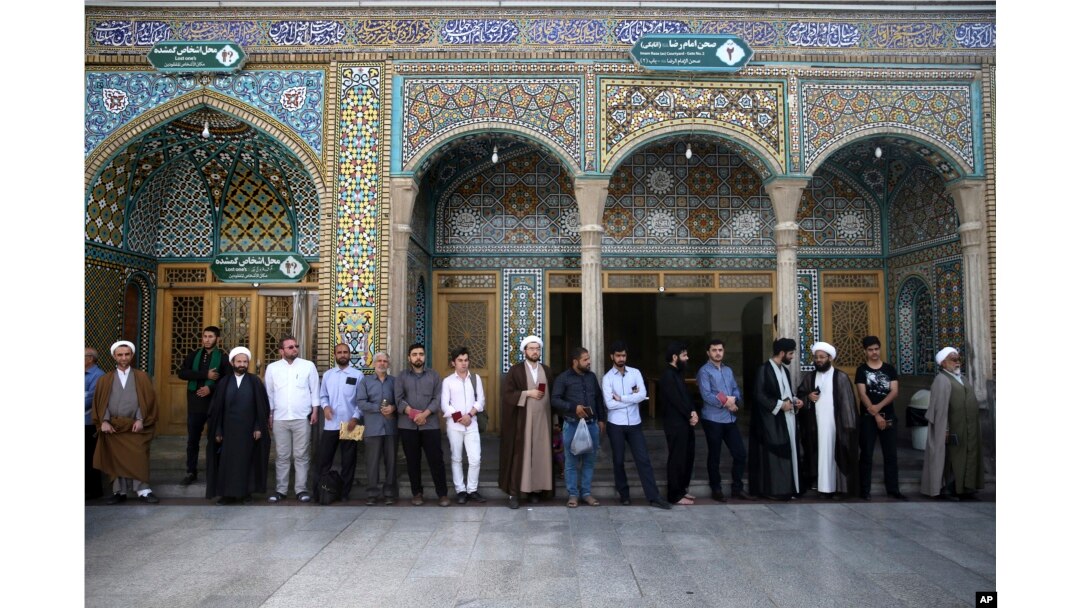 Iranian men queue to vote for the presidential and municipal councils elections, in the city of Qom, south of the capital Tehran, Iran, May 19, 2017.