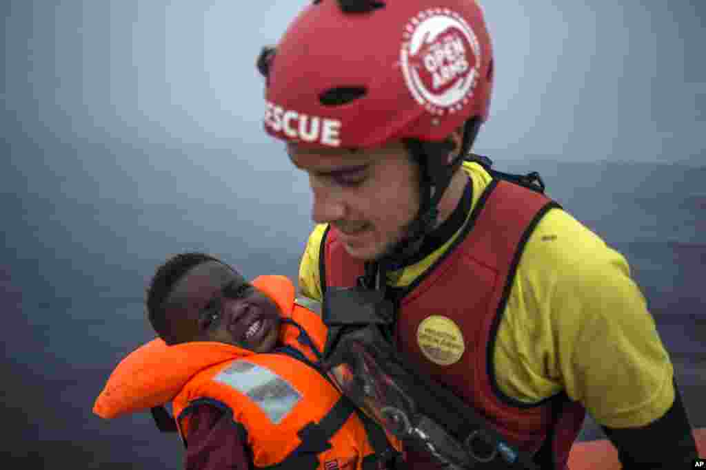 A member of Spanish NGO Pro activa Open Arms holds a baby rescued at a dinghy at Alboran Sea, about 40 miles (64 kms) from the Spanish coasts.