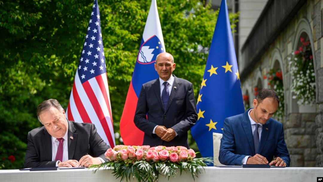 US Secretary of State Mike Pompeo, left, and Slovenia's Foreign Minister Anze Logar sign an agreement on fifth-generation internet technology as Slovenia's Prime Minister Janez Jansa stands at center, in Bled, Slovenia, Aug. 13, 2020.