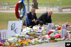 President Obama and Vice President Biden crouch in front of a memorial for Orlando victims.