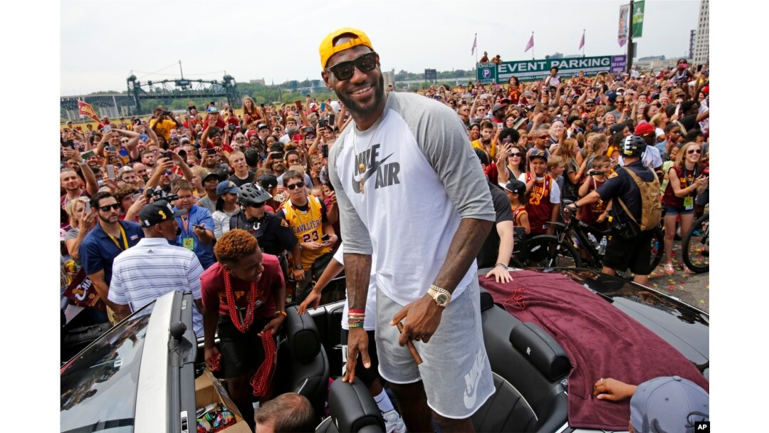 Cleveland superstar LeBron James, center, stands in the back of a Rolls Royce at the beginning of a parade in downtown Cleveland, Wedensday, June 22, 2016, celebrating the Cavaliers' NBA Championship.