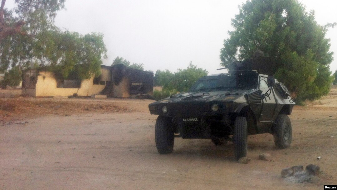 Watamotar soja tana gadi a kifar wani gida da aka kona a garin Bama, Jihar Borno, ran 7 Mayu 2013 