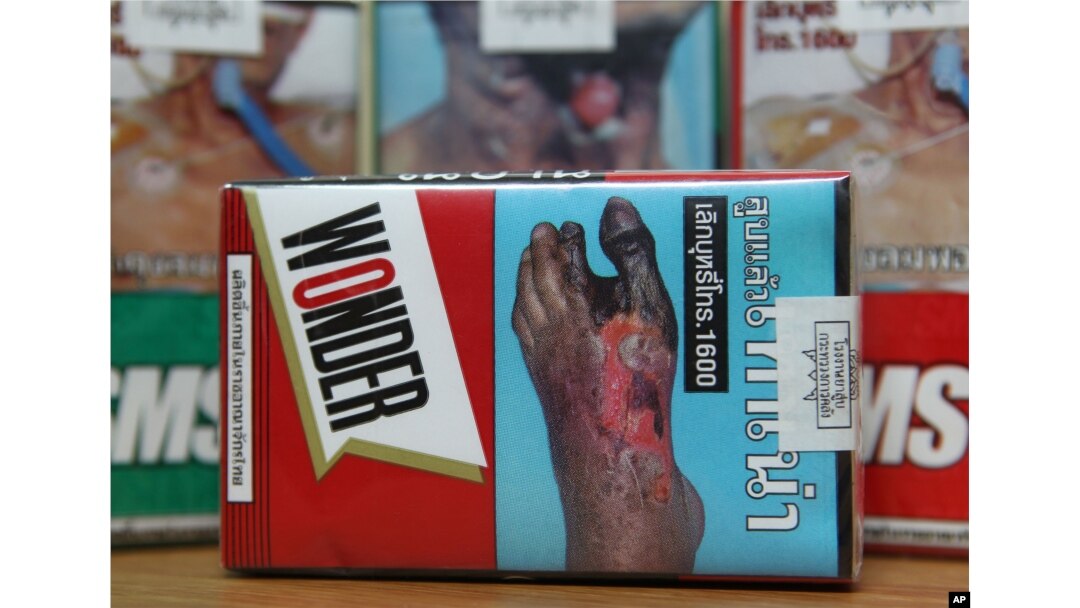 FILE - Warning signs are printed on packs of cigarettes for sale in Bangkok, Thailand.