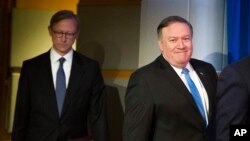 El Secretario de Estado, Mike Pompeo, a la derecha, seguido de Brian Hook, el representante especial para Iran, caminan hacia una rueda de prensa en el Departamento de Estado. 