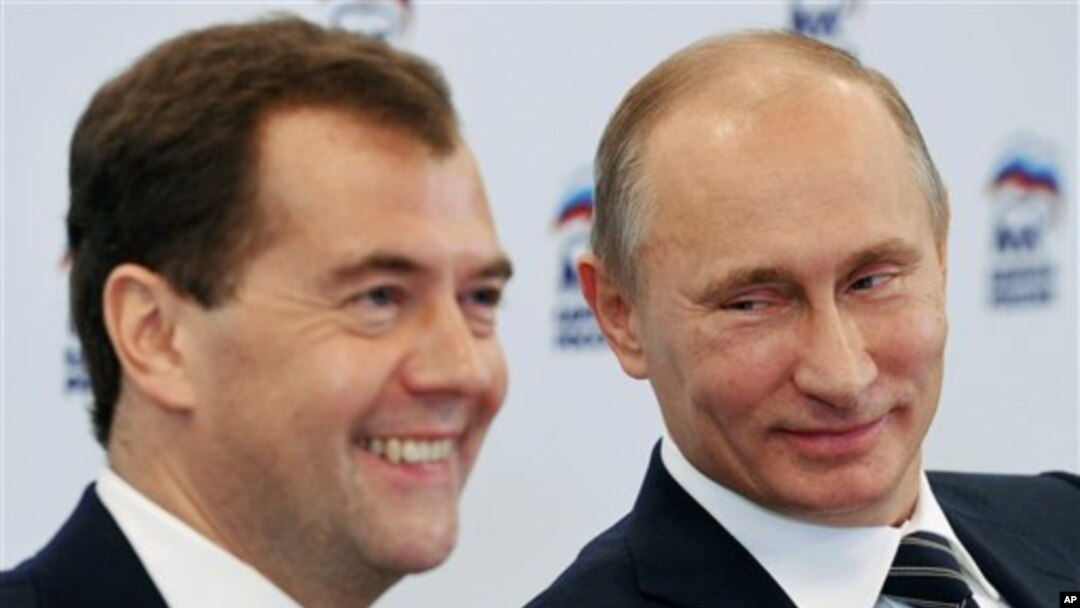 Russian President Dmitry Medvedev, left, and Russian Prime Minister Vladimir Putin participate in a video conference with regional offices of the United Russia party, at the party's headquarters, Moscow, October 21, 2011.