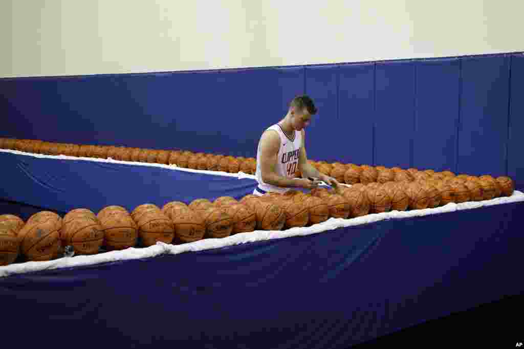 Los Angeles Clippers' Marshall Plumlee signs his autograph many times over during an NBA basketball media day, Sept. 25, 2017, in Los Angeles, California. 8