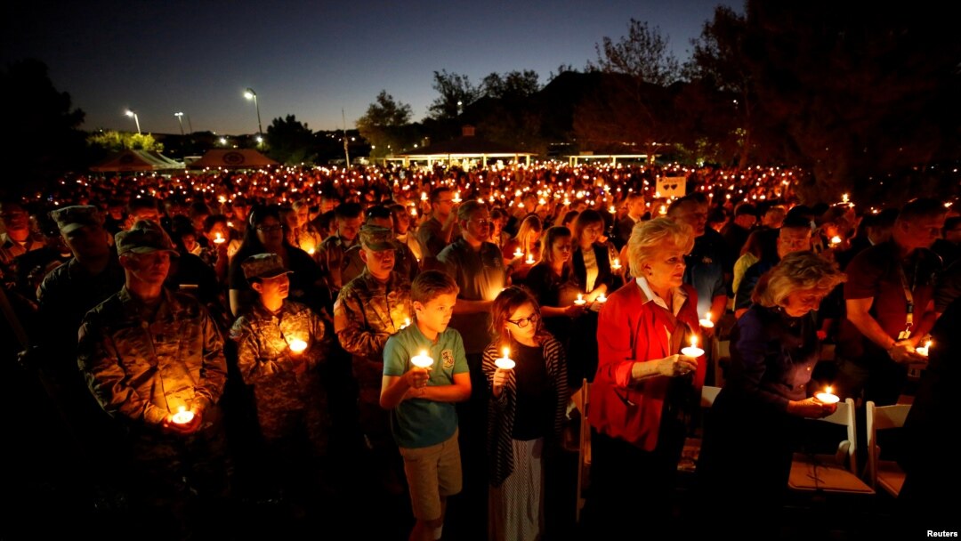 People hold candles during a memorial service for Charleston Hartfield, an off-duty Las Vegas police officer who was killed during the Route 91 music festival mass shooting, in Las Vegas, Nevada, Oct. 5, 2017.