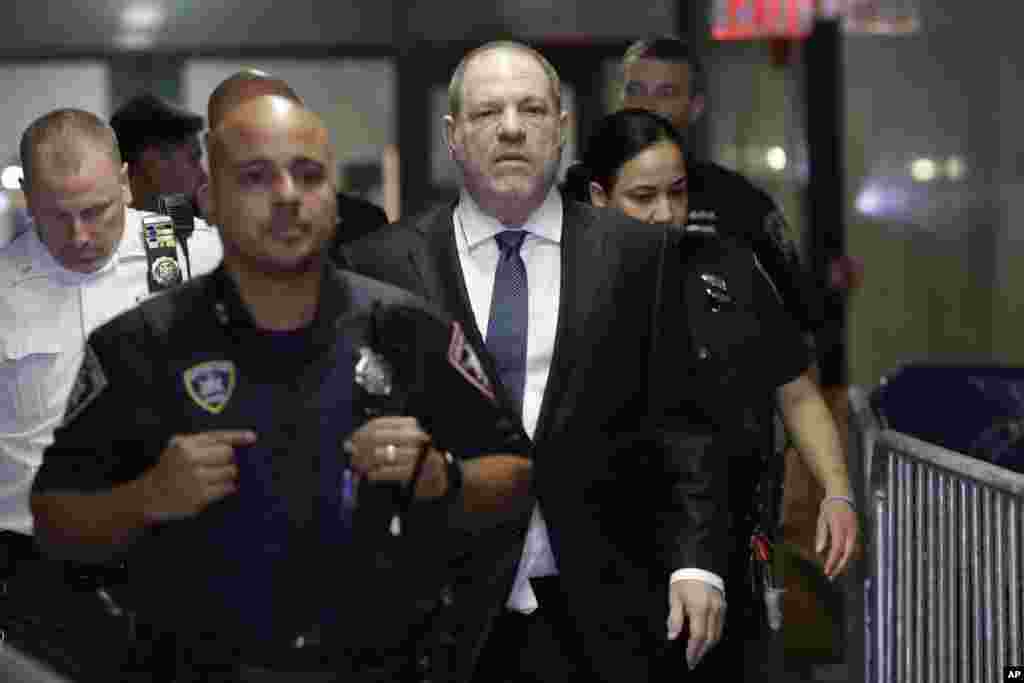 Harvey Weinstein, center, enters State Supreme Court in New York. Manhattan's district attorney dropped part of the criminal sexual assault case against the former film producer after evidence emerged that cast doubt on the account one of his three accusers provided to the grand jury.