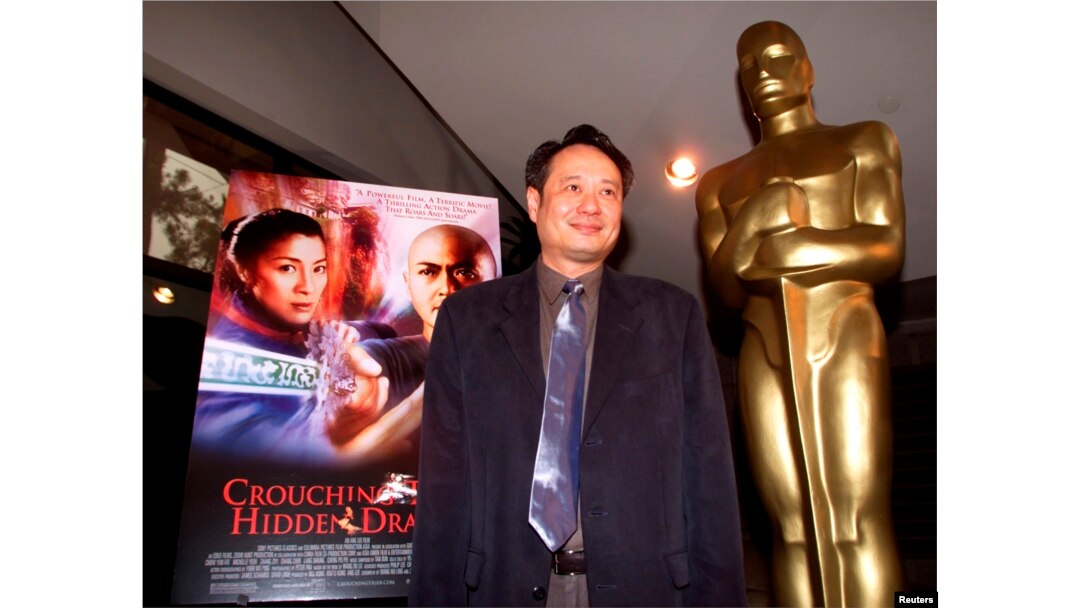 FILE - Director Ang Lee stands next to the movie poster for his Academy Award-nominated film, "Crouching Tiger, Hidden Dragon," at the Academy of Motion Pictures of Arts and Sciences in Beverly Hills, March 23, 2001.