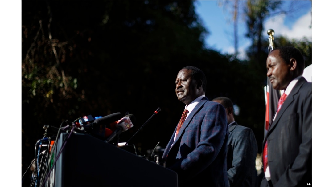 Kenya's opposition leader Raila Odinga, center, accompanied by party official Kalonzo Musyoka, right, announces they will challenge the results of the August 8 presidential election in the Supreme Court.
