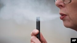 Chantel Williams exhales a puff of vapor from a Juul pen in Vancouver, Wash., April 16, 2019.