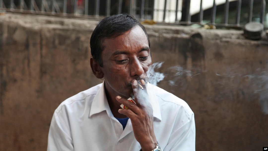 FILE- An Indian man smokes a cigarette in New Delhi, India, Nov. 3, 2016.