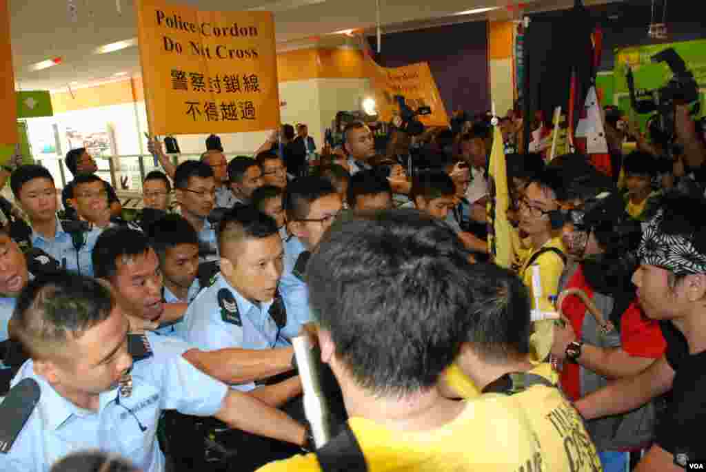 十多名熱血公民成員衝擊北京官員政改簡介會演講廳外的警方鐵馬陣,警方3度在室內施放胡椒噴霧,制止示威者衝擊