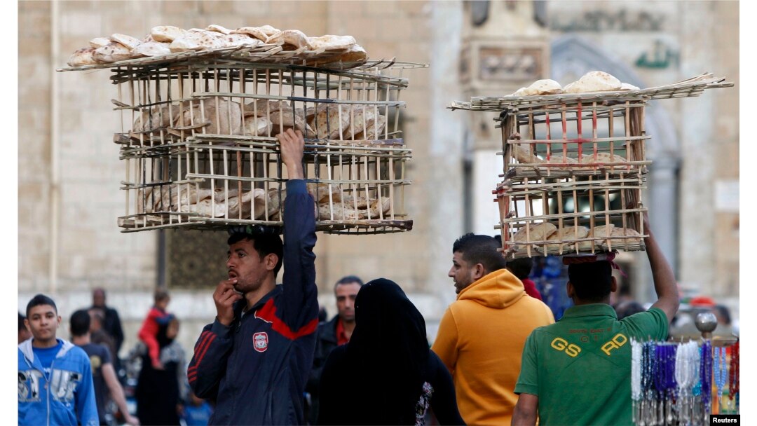 Egyptian men sell bread as they balance the trays on their heads near Al Hussein mosque in Old Cairo, Mar. 17, 2013.