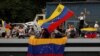 Partidarios del candidato presidencial opositor venezolano Edmundo González ondean banderas de Venezuela antes de su mitin de cierre de campaña, en Caracas, Venezuela, el 25 de julio de 2024. [Foto: Reuters]