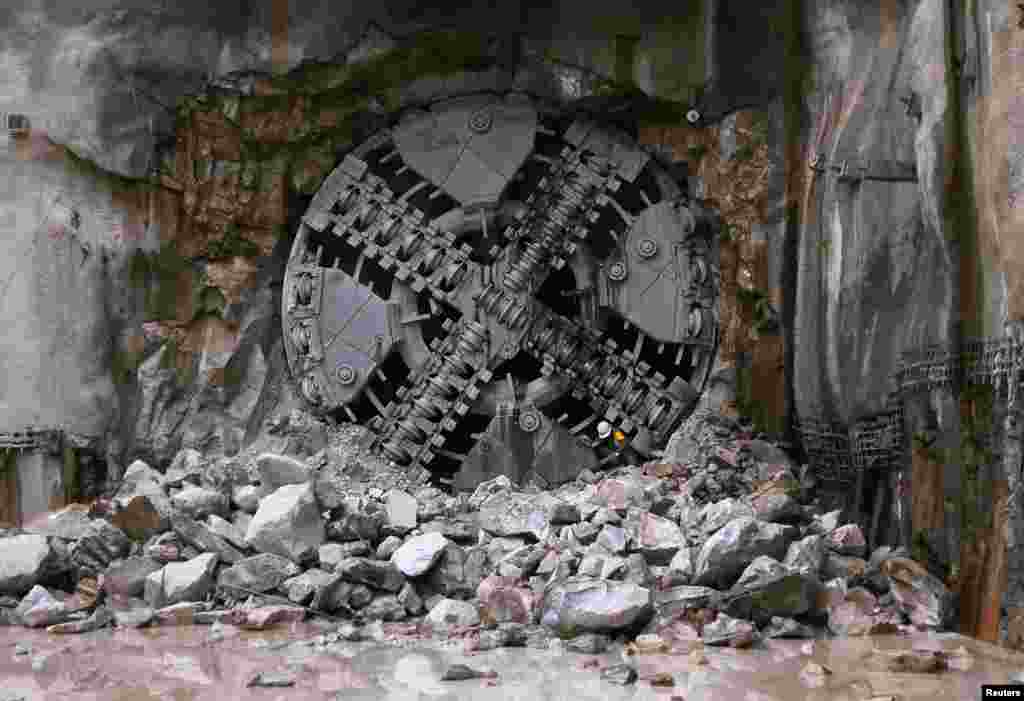 An engineer crawls through a hole in a Tunnel Boring Machine (TBM) during the breakthrough of a tunnel in Kuala Lumpur, Malaysia. The world's first variable density TBM has completed the first section of the 9.5 km (5 miles) twin tunnels of the Klang Valley MRT (Mass Rapid Transit) line.